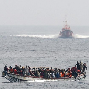 Flüchtlingsboot &amp; sich näherndes spanisches Seenotrettungsboot